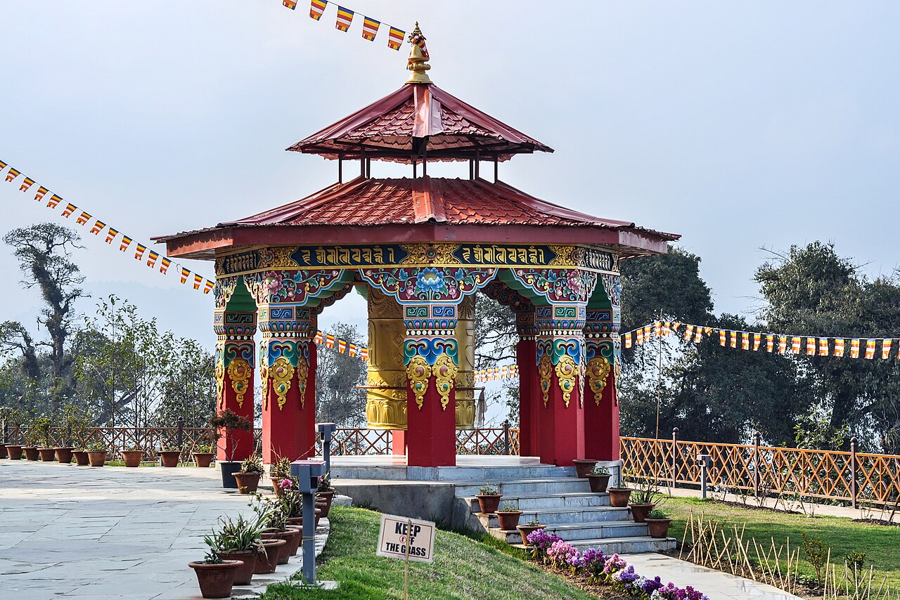 The colossal golden Chenrezig statue flanked by giant golden prayer wheels